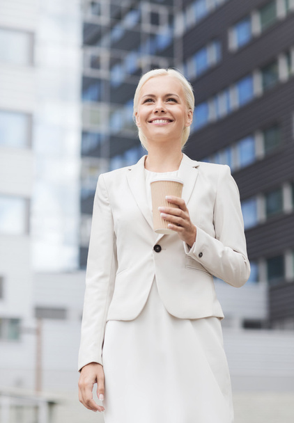smiling businesswoman with paper cup outdoors - Φωτογραφία, εικόνα
