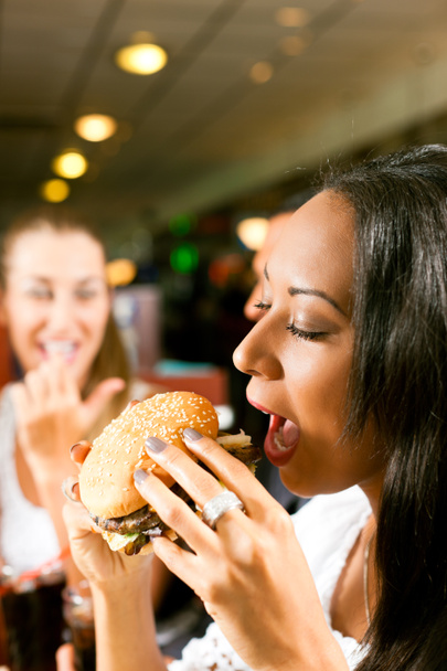 Amigos comendo fast food em um restaurante
 - Foto, Imagem