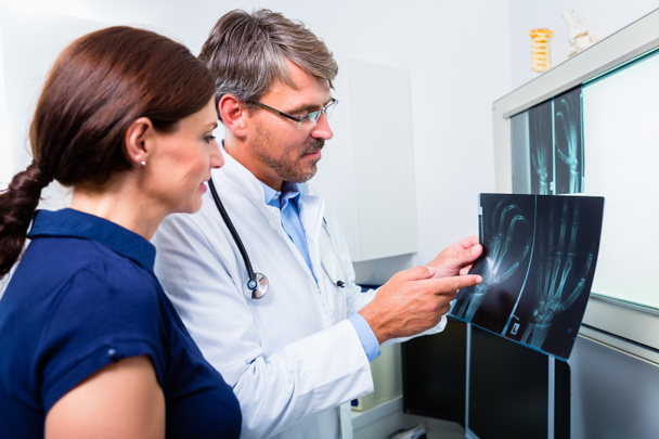 Doctor con imagen de rayos X de la mano del paciente
 - Foto, imagen