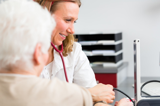 Lékař měří krevní tlak staršího pacienta - Fotografie, Obrázek