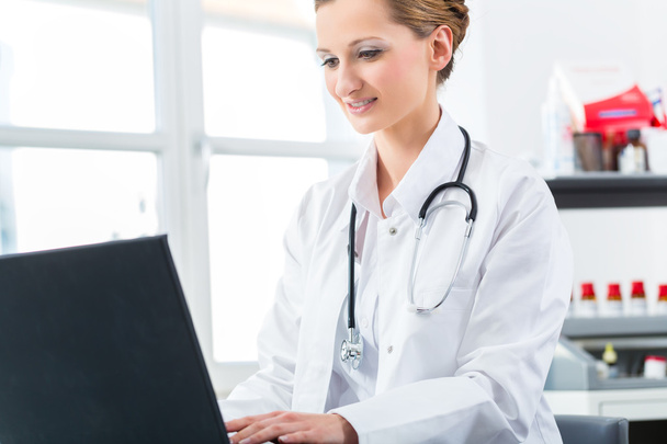 Doctora escribiendo en PC en su clínica
 - Foto, Imagen