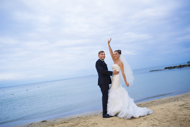 Güzel yeni evliler sahilde duran. - Fotoğraf, Görsel