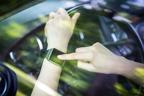 Uma mulher usa smartwatch no carro
. - Foto, Imagem