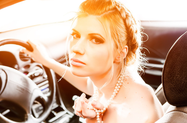 Молода жінка в перловому намисті сиділа на сидінні водіїв її c
 - Фото, зображення