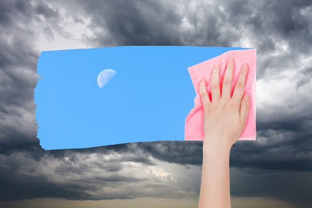 рука видаляє штормові хмари рожевою тканиною
 - Фото, зображення