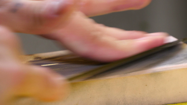 Суші-кухар заточення його ножа з рожевими камінь - Кадри, відео
