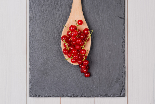 Currants in a wooden spoon - Foto, imagen