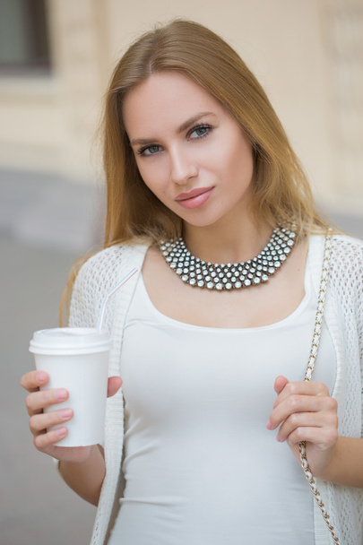 stylish woman drinking coffee to go in a city street - Photo, Image