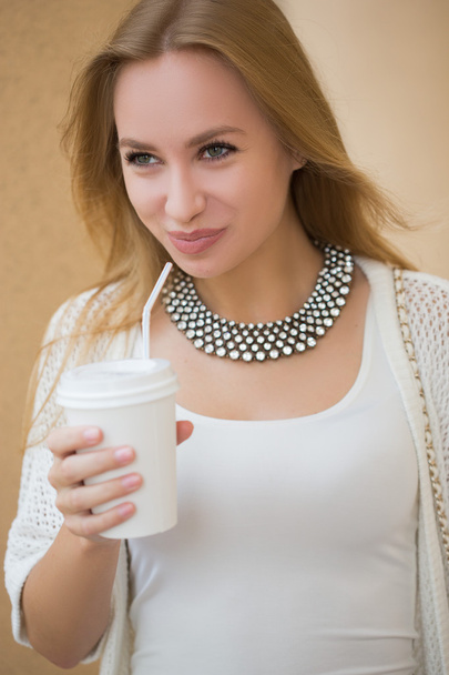 stylish woman drinking coffee to go in a city street - Photo, Image