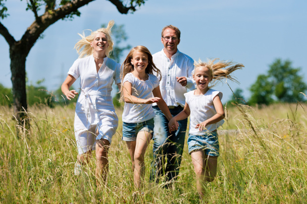 Familia corriendo en el prado
 - Foto, Imagen