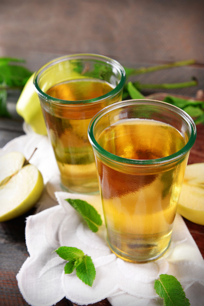 Glasses of apple juice on wooden table, closeup - Фото, зображення