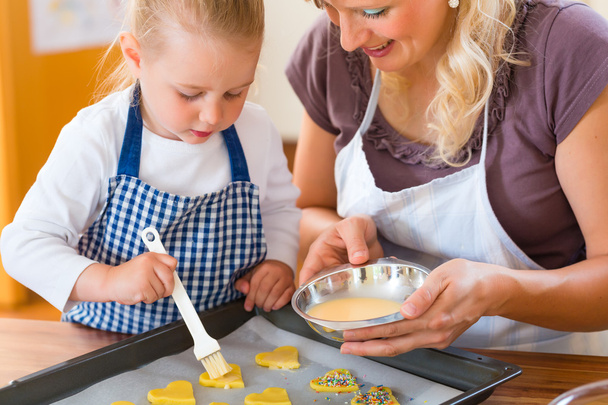 Mother and daughter baking cookies together - Photo, Image