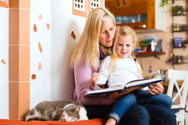Mutter liest dem Kind zu Hause eine Nachtgeschichte vor - Foto, Bild