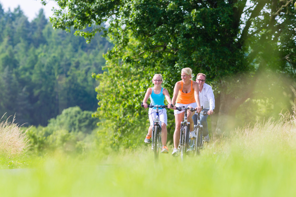 Семья с велосипедным туром выходного дня на свежем воздухе
 - Фото, изображение