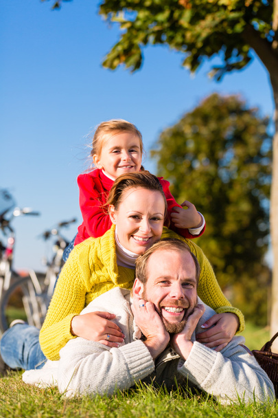 Familia con bicicleta en el parque en otoño
 - Foto, imagen