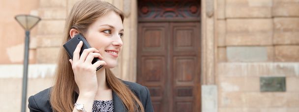 business woman smiling and making a phone call with her smartphone - Fotoğraf, Görsel