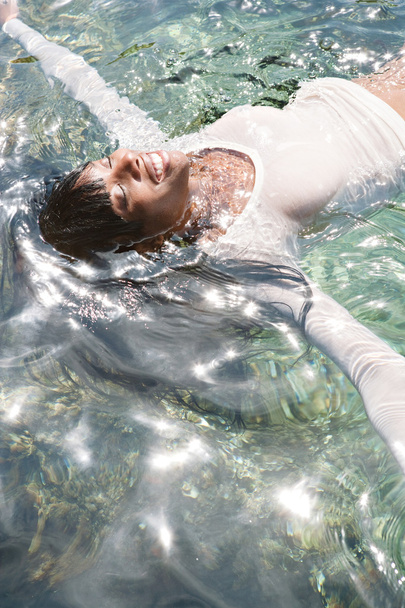 mujer negra nadando y flotando en un mar
 - Foto, imagen