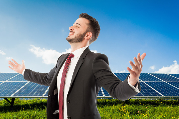 Homme d'affaires prospère avec les bras écartés sur Solarpower photovo
 - Photo, image