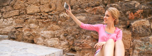 woman taking holiday pictures with her smartphone - Foto, afbeelding