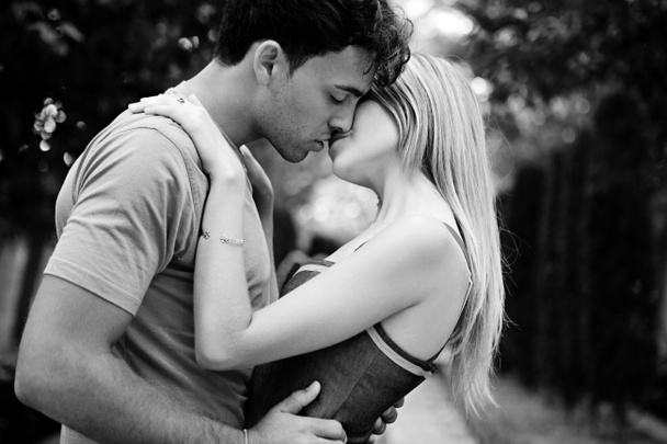 romantic young couple kissing and embracing - 写真・画像