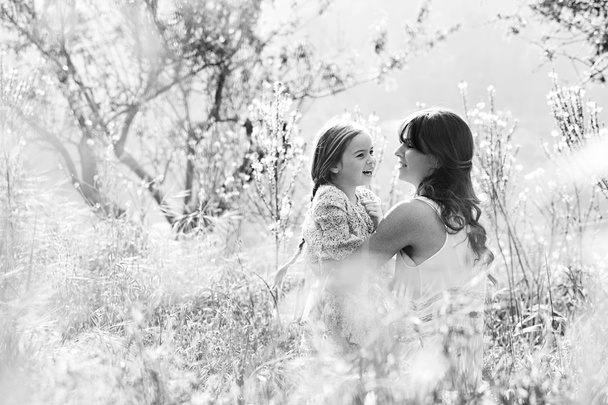 Mother and daughter hugging in a spring field - Foto, afbeelding