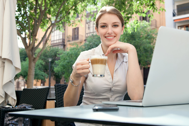 business woman at a cafe using a laptop computer - Zdjęcie, obraz