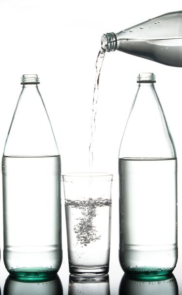 Pouring water from a bottle. - Foto, Bild