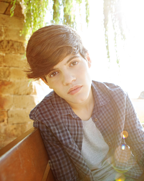 attraente adolescente ragazzo seduto su una panchina di legno
 - Foto, immagini