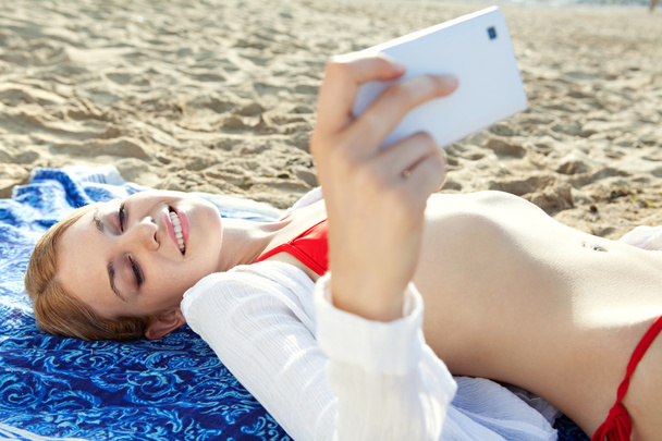 woman using smartphone on the beach - 写真・画像