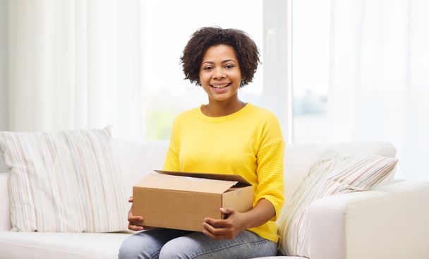 happy african young woman with parcel box at home - Φωτογραφία, εικόνα