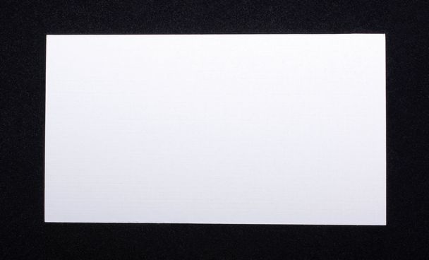 White business card isolated on black velvet background. Empty s - Valokuva, kuva
