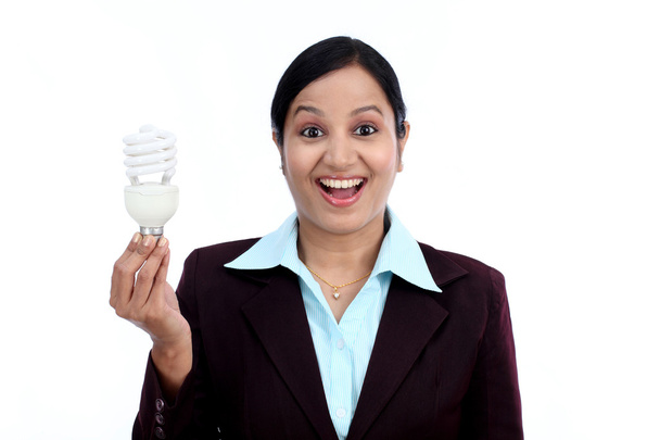 Young Indian business woman holding bulb  - Fotó, kép