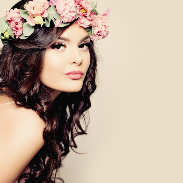 Όμορφη νεαρή γυναίκα με καλοκαίρι ροζ λουλούδια. Καιρό Permed μπούκλα - Φωτογραφία, εικόνα