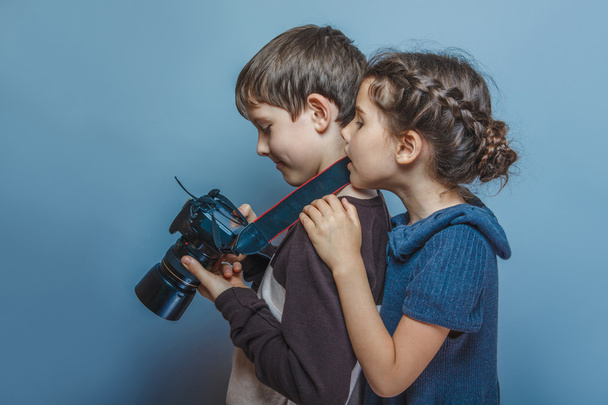 Мальчик-подросток с девушкой, смотрящей фотографии на камеру
 - Фото, изображение
