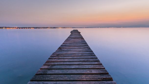 Long quai en bois sur le lac de Garde au coucher du soleil
 - Photo, image