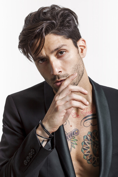 Sexy tattooed man closeup portrait wearing black jacket and look - 写真・画像