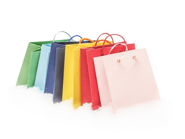 The red, pink, yellow, green and blue gift packages stand on snow, isolated on the white - Foto, Imagen