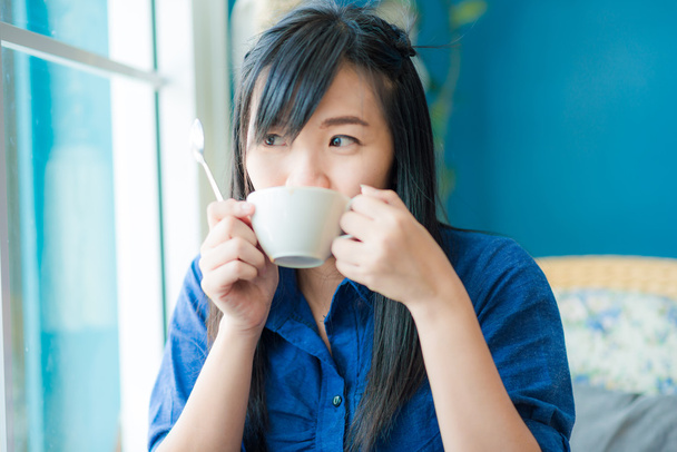 Jeune femme asiatique boire du café au café
  - Photo, image