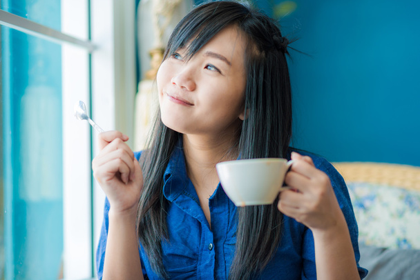 Beautiful young woman with a white cup of coffee - Фото, изображение