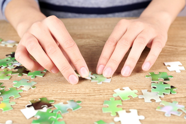 Female hands assembling puzzle - Foto, Imagen