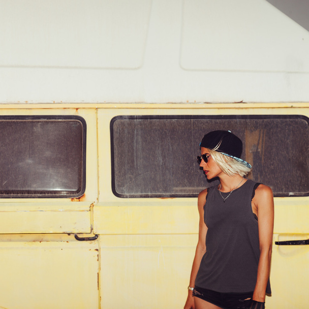 Stylish girl stands near minibus. Surf fashion style - Φωτογραφία, εικόνα