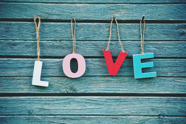 The word Love with wooden multi colored letters on natural board - 写真・画像