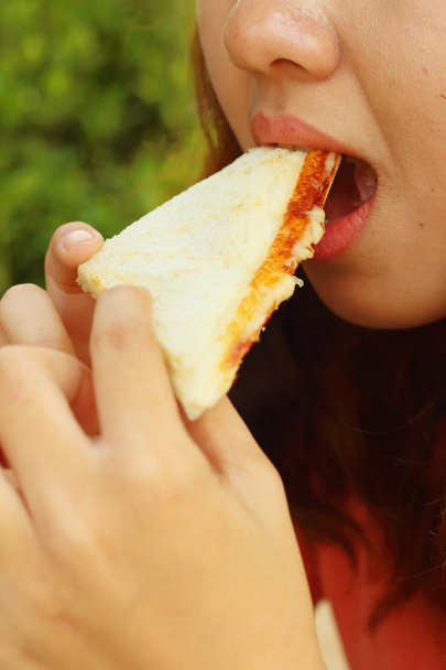 Kobieta jedzenie kanapka z szynką i serem. - Zdjęcie, obraz