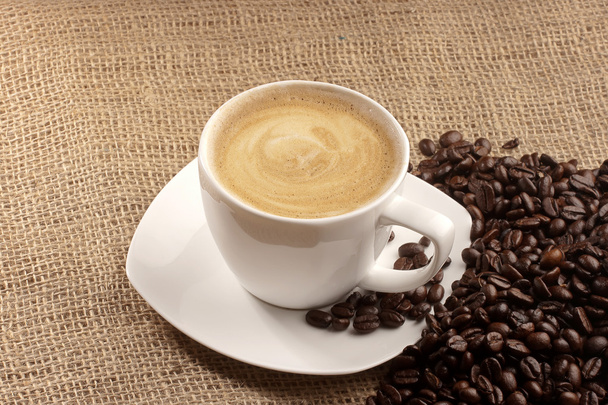 Cappuccino and coffee beans over sacking - Фото, зображення