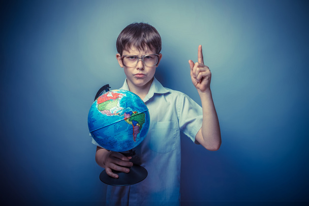 ein etwa zehnjähriger Junge von europäischem Aussehen in hellbraunem Hemd und  - Foto, Bild