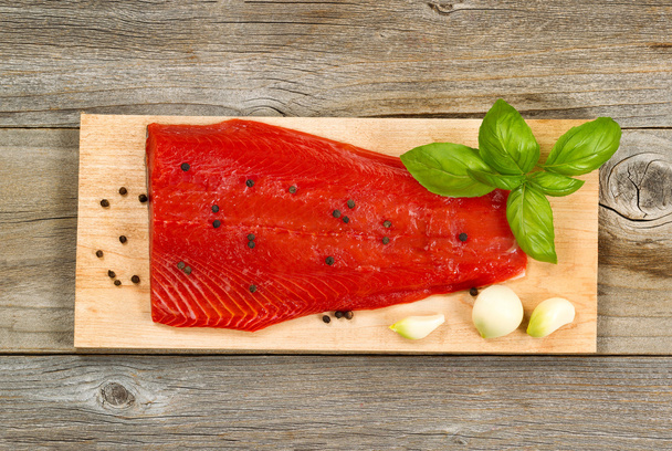 Filete de salmón rojo fresco sobre tabla de cocción de cedro con especias y h
 - Foto, imagen