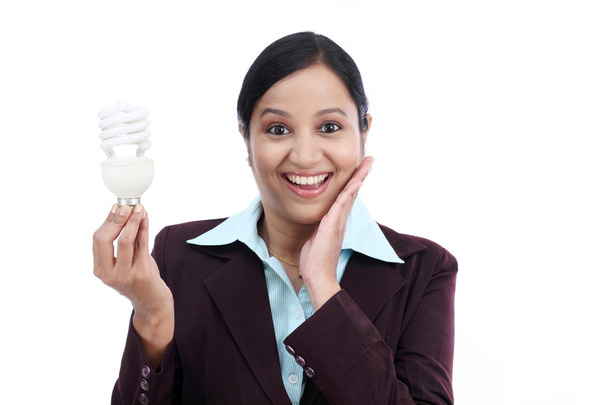 Young Indian business woman holding bulb  - Фото, изображение