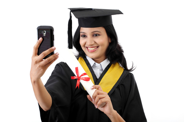 Young female graduated student taking selfie - Фото, изображение