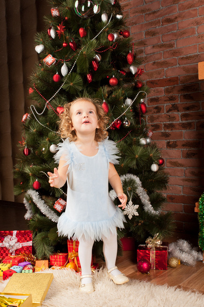 Little girl staying near Christmas tree - Valokuva, kuva