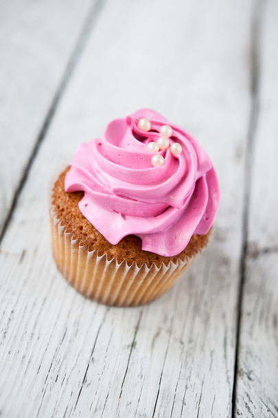 Kuppikakut (muffinit) vaaleanpunaisella kermalla
 - Valokuva, kuva